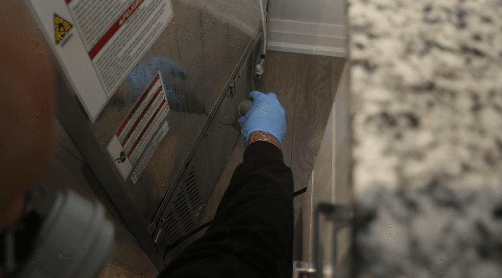 Food preparation factories pest control Toronto showing Pesticon technician performing targeted pest treatment near equipment